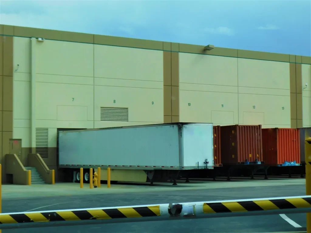 Remolques en muelles de carga numerados, gestionados eficientemente mediante automatización y control industrial.