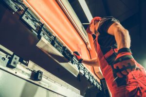 Toma fotográfica en cenital de trabajador usando cortinas contra fuego color naranja